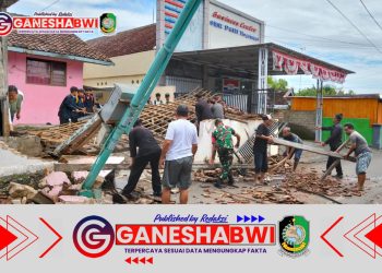Babinsa Koramil Rogojampi Bersama Warga Bersihkan Puing Tempat Parkir yang Roboh